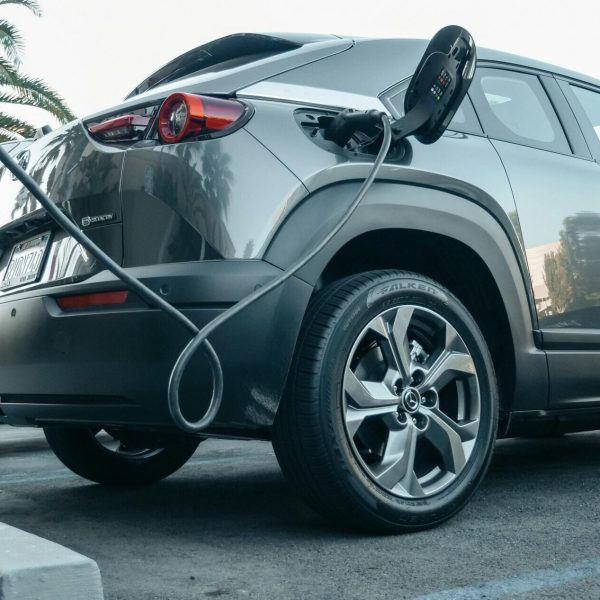 Modern electric vehicle charging at an outdoor station in daylight.